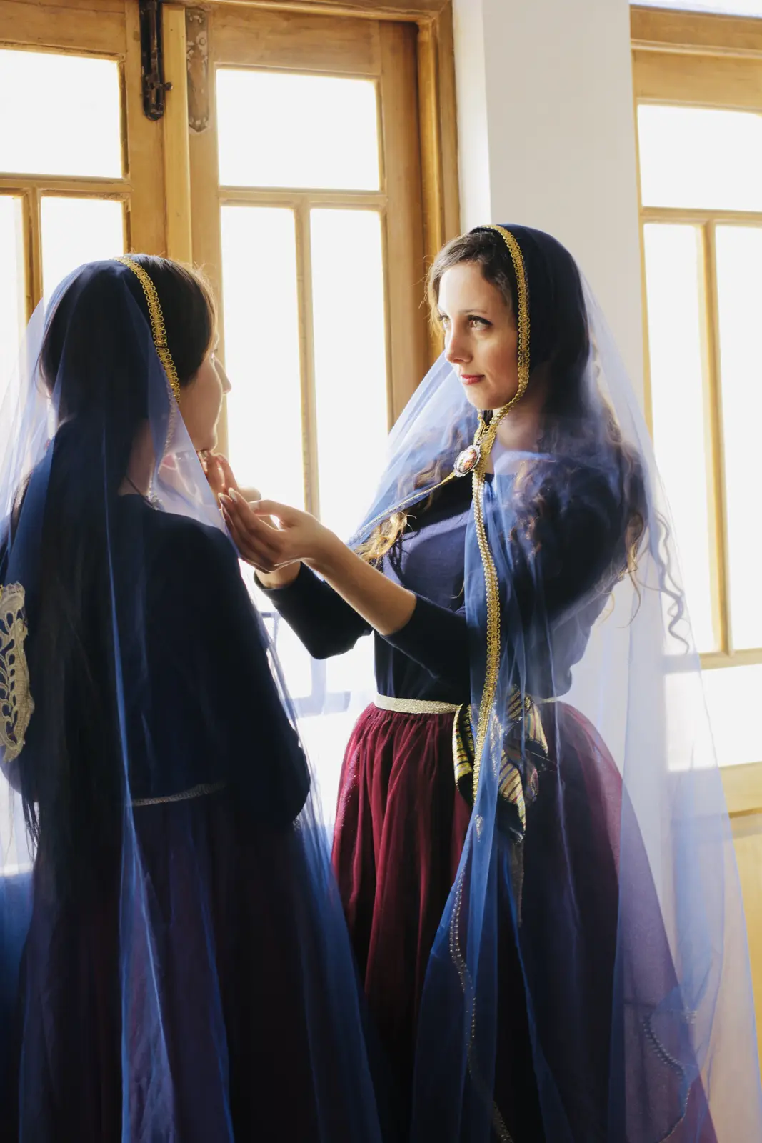Two Miniature dancers preparing a veil and costume