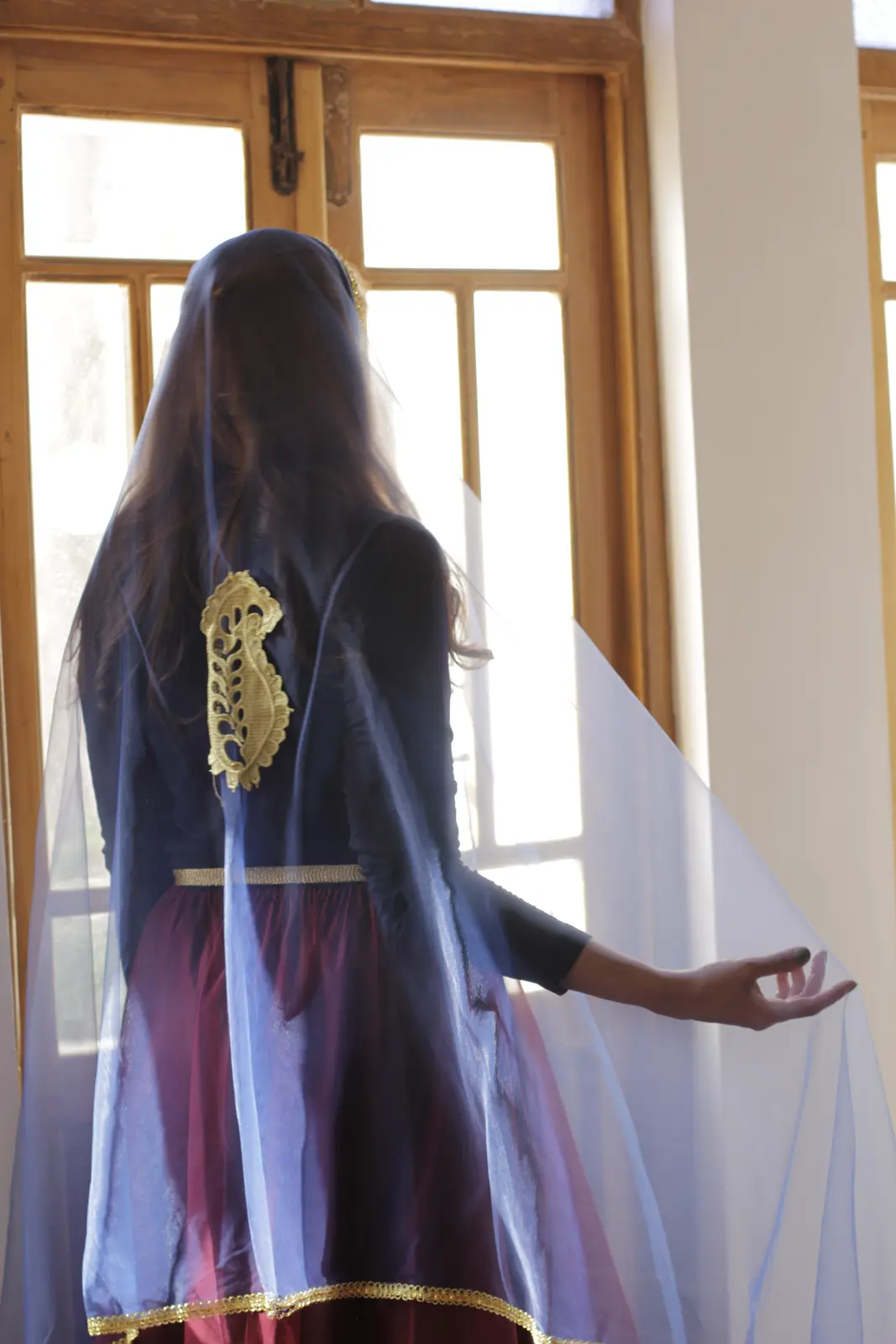 A Miniature dancer studying gesture beside a tall window
